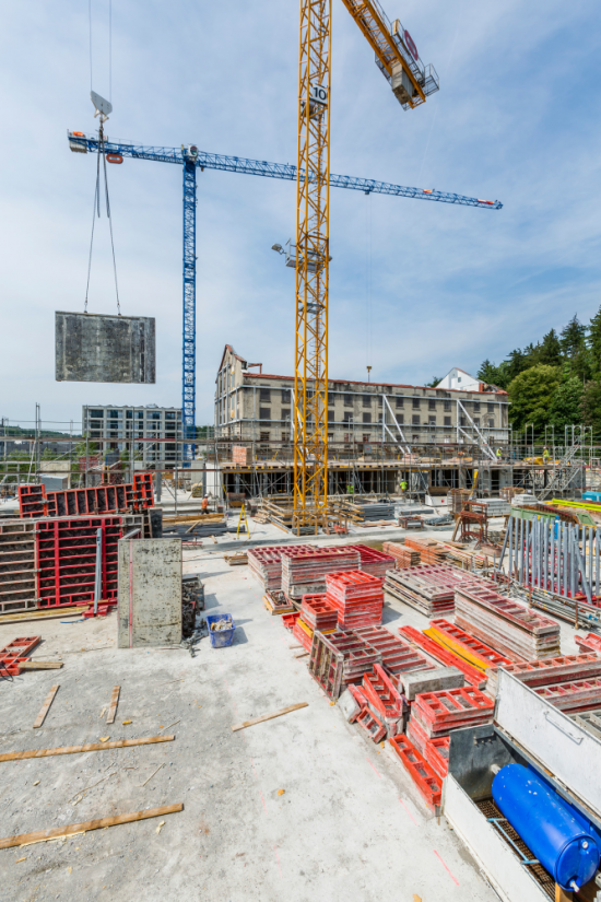 Blick auf die Baustelle der zweiten Etappe, im Hintergrund ist die denkmalgeschützte Spinnerei sichtbar.