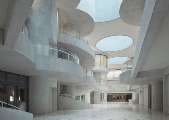 Im zentralen Atrium thematisieren Christ & Gantenbein architektonisch-zeichenhaft das Räderwerk. Referenz ist die Conche, mit deren Erfindung der Schweizer Chocolatier Lindt die Schokoladenerzeugung revolutionierte.